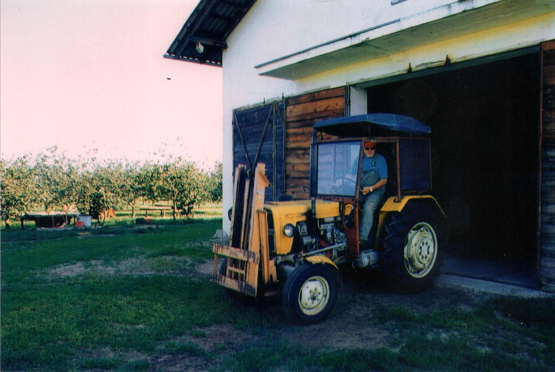 Orchard and airport owner, Zbigniew Kowalski, personally operating a necessary agricultural tractor in the orchard.