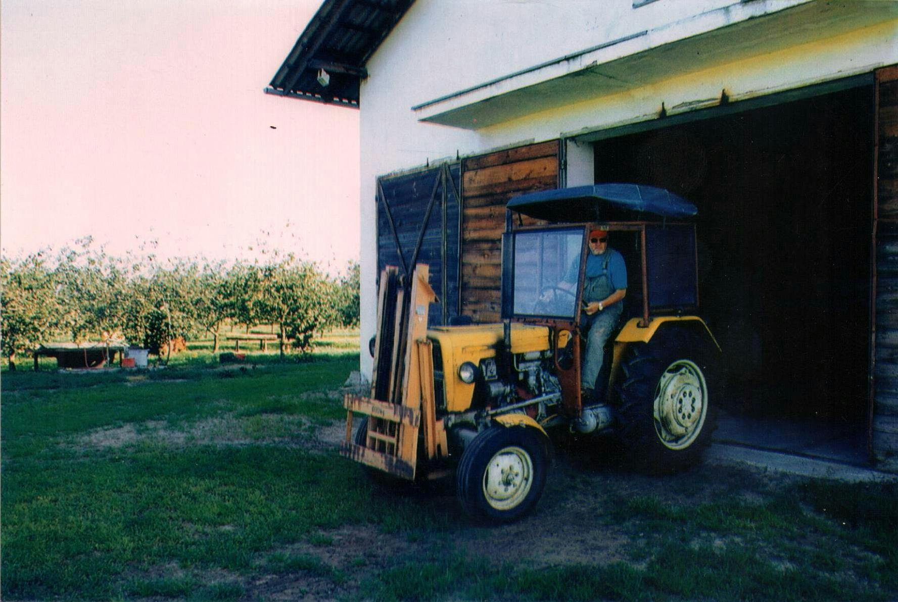 Właściciel sadu i lotniska, Zbigniew Kowalski, osobiście obsługuje ciągnik rolniczy, niezbędny w gospodarstwie sadowniczym.